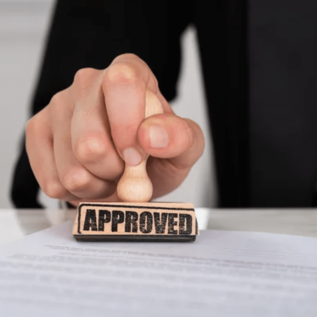A rubber stamp marked with "Approved," signifying official approval or validation.